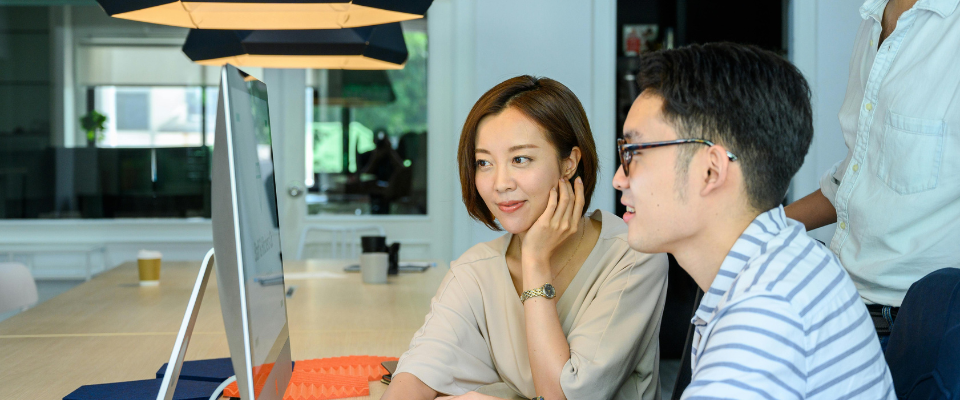 three professionals are facing the desktop and collaborating on an association content