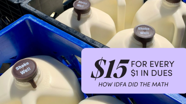 Gallon jugs of milk in a blue dairy crate, with a label reading “$15 for every $1 in dues: how IDFA did the math.”